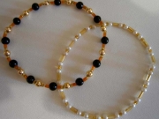 Braccialetti con perle nere, bianche e oro